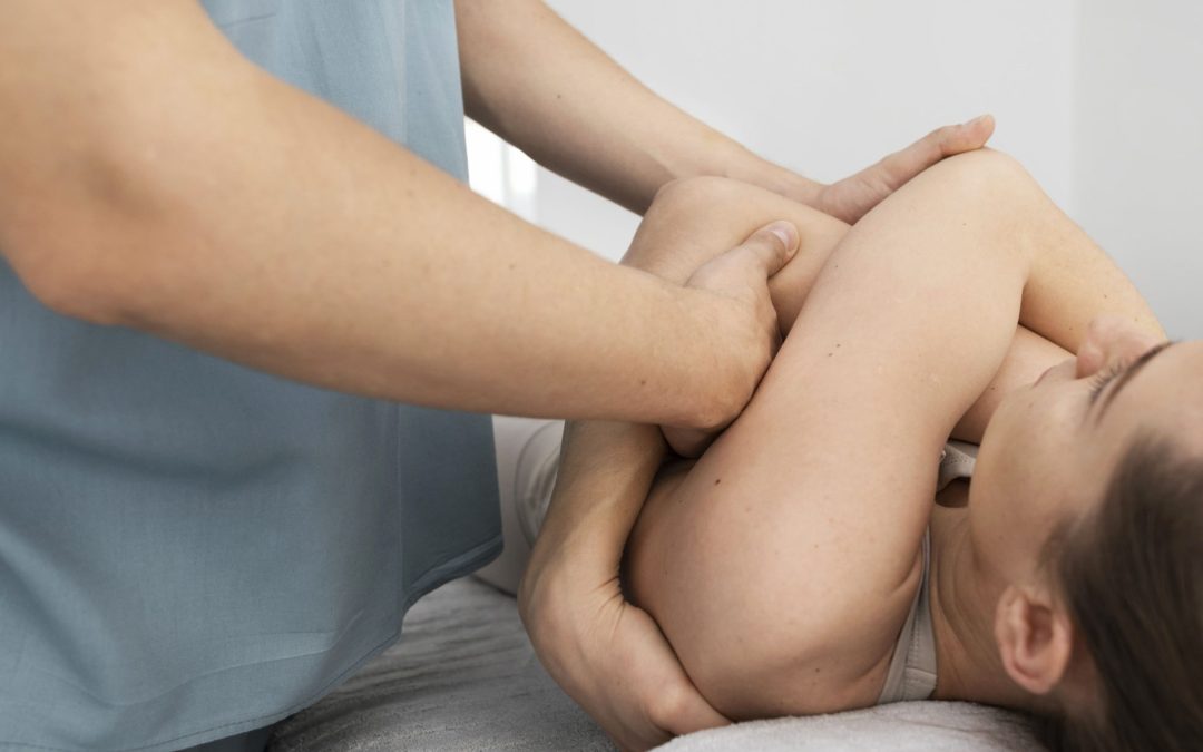 Fisioterapeuta realizando tratamiento de fisioterapia postoperatoria tras aumento de pecho a una paciente en consulta